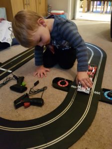 Joshua placing cars on the finish line of the Scalextric Le Mans Sports Cars track